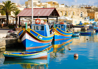 Fototapeta na wymiar Luzzu famous fishing boats in Marsaxlokk - Malta