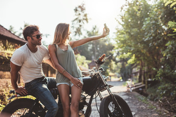 Young couple taking selfie on motorcycle