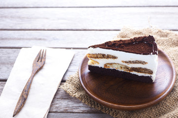 Close up of Tisamisu layer cake on a wooden plate.