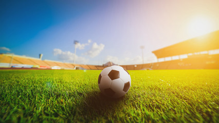 Soccer ball on the grass grass in soccer stadium , sunset..
