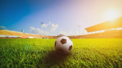 Keuken foto achterwand Voetbal Voetbalbal op het grasgras in voetbalstadion, zonsondergang..