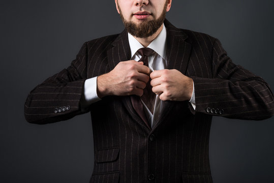 Attractive man in a suit lures, undresses and removes his tie