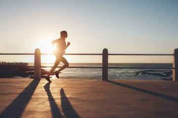 Sportswoman training on seaside promenade at sunset © Jacob Lund