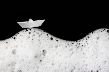 Foam bubbles abstract black background. Detergent. White textile boat. Wash.