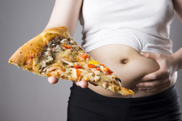 Fat woman with a piece of pizza in hand, obesity concept