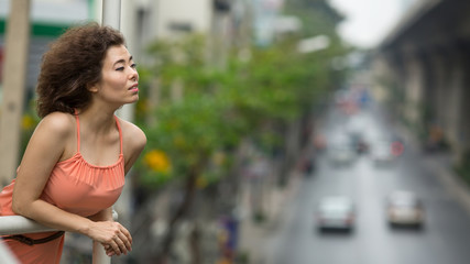 Asian girl portrait in a big city, the background blurred track.