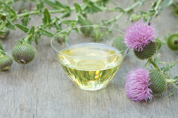 thistle oil container with thistle flowers