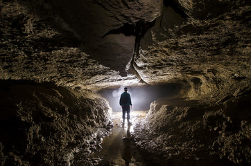 caver silhouette in dark cave
