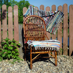 Wicker chair on the wooden fence