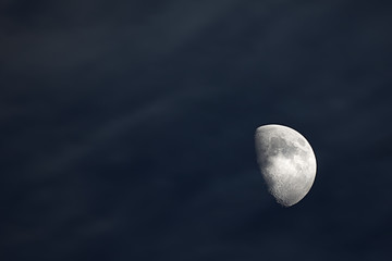 Half moon in the cloudy sky