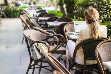 Business woman working with the laptop at cafe's garden.