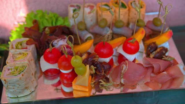 beautifully decorated buffet table, canapés, rolls, vegetables, fish