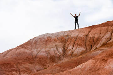 man with hands raised standing at the top of Red Mountain