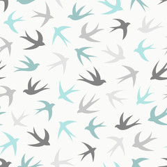 Seamless pattern with a flock of swallows. Vintage background of silhouettes of birds in the sky. Vector illustration.