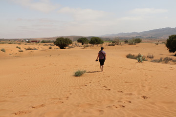 Fototapeta na wymiar Tourist is in the desert in a summer day