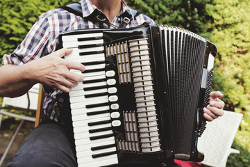 homme senior jouant de l'accordéon dans nature