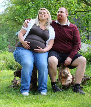 Overweight Couple. Healthy Lifestyle Concept. Obese Adults On Garden Bench. Happy Family Together.