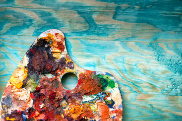 Obraz premium Painting palette on colorful wooden background