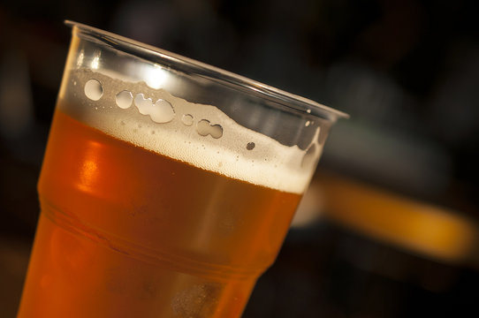 Brown Beer , Lager Or Ale In A Plastic Glass At A Bar