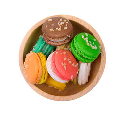top view of macaroons in wooden bowl on white background