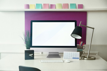 Stylish workplace with computer and interior decorations