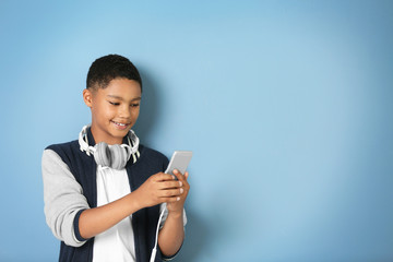 African American boy with headphones on blue background