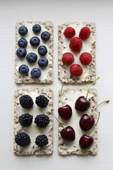 Naklejka na ściany i meble Healthy sandwiches with berries on wooden background