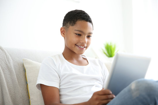African American boy with tablet on couch