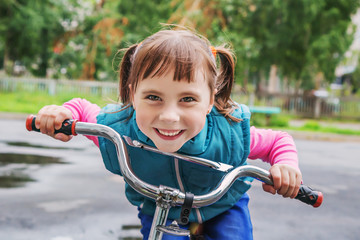 Fototapeta na wymiar Smiling little girl on a bicycle.