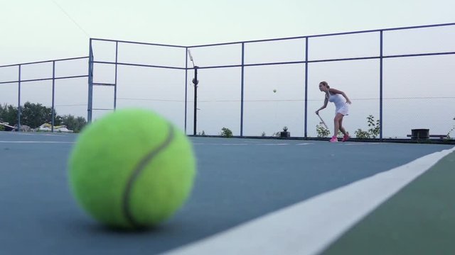 Tennis court with tennis balls and player. Slow motion