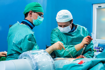 Orthopedic surgeons operating a human spine trauma.