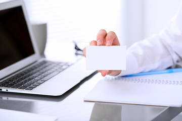 Close-up of business woman giving a visit card