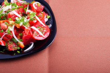 Top view of the salad of tomatoes, peppers and onions