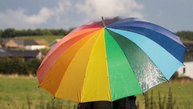A person with colorful umbrella in the rain - 1080p HD video
