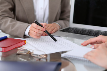 Group of business people at meeting  discussing financial results. Women pointing into laptop computer monitor