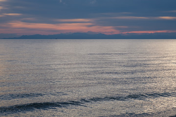 Small boat on the ocean at dusk .