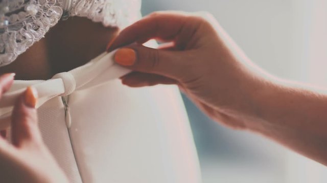 Buttoning the wedding dress