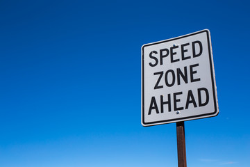 Speed warning traffic sign for transportation and all vehicles to be aware and careful for safety with blue sky background.