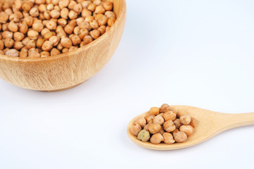 A spoon of dried chickpeas on a white background.