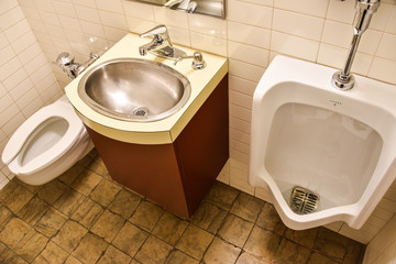Toilet sink and urinal next to each other