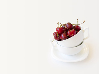 Juicy tasty red sweet cherries in mug on white background. Selective focus
