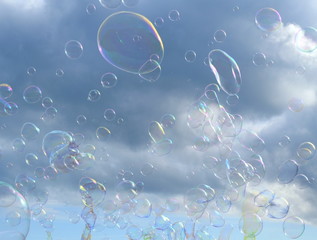 Large group of soap bubbles in the air against clouds