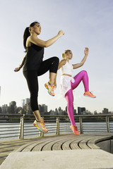 Two girl working out in the park by the bay