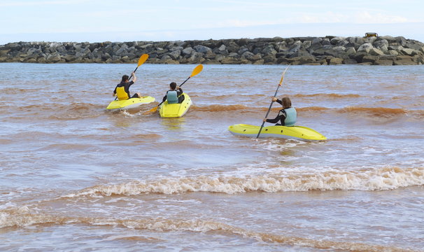 Three yellow kayaks on the beach in Sidmouth, Devon