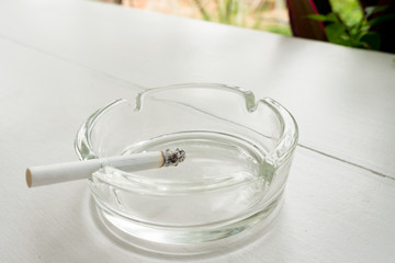 cigarette in glass ashtray