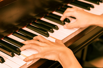 Woman play the piano. Vintage filter effect.