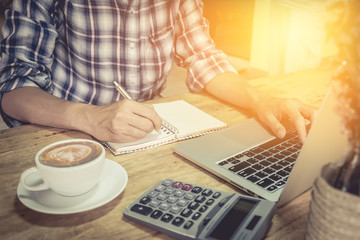 close up hand of business man using laptop computer and write on
