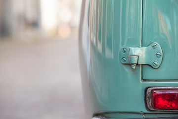 Ancient Car Detail / Closeup taillight and hinge of the rear door at mint green oldtimer car seen...