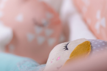 Toy ragdoll sleeping on a baby crib