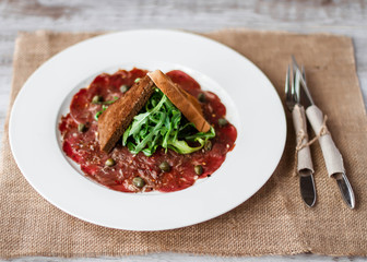 Meat carpaccio of beef on wood table